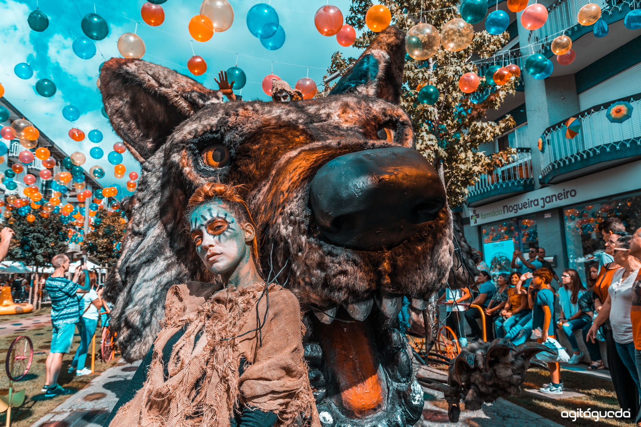 Performer ao lado de escultura de lobo gigante em evento de rua