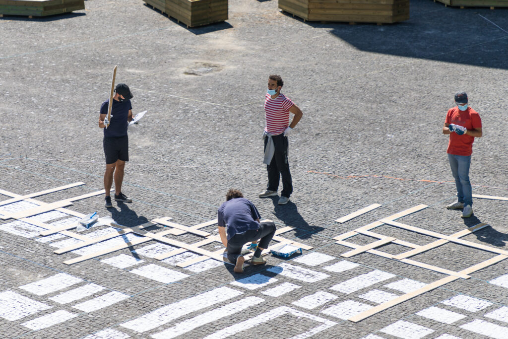 Participante a pintar o espaço público no projeto PLANTEIA