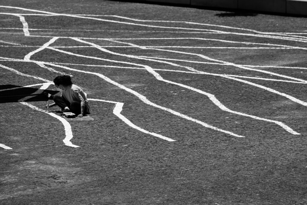 Participante a pintar o espaço público no projeto PLANTEIA