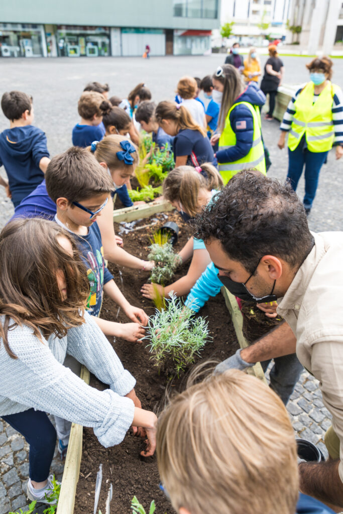 Crianças a plantar durante oficina no projeto PLANTEIA