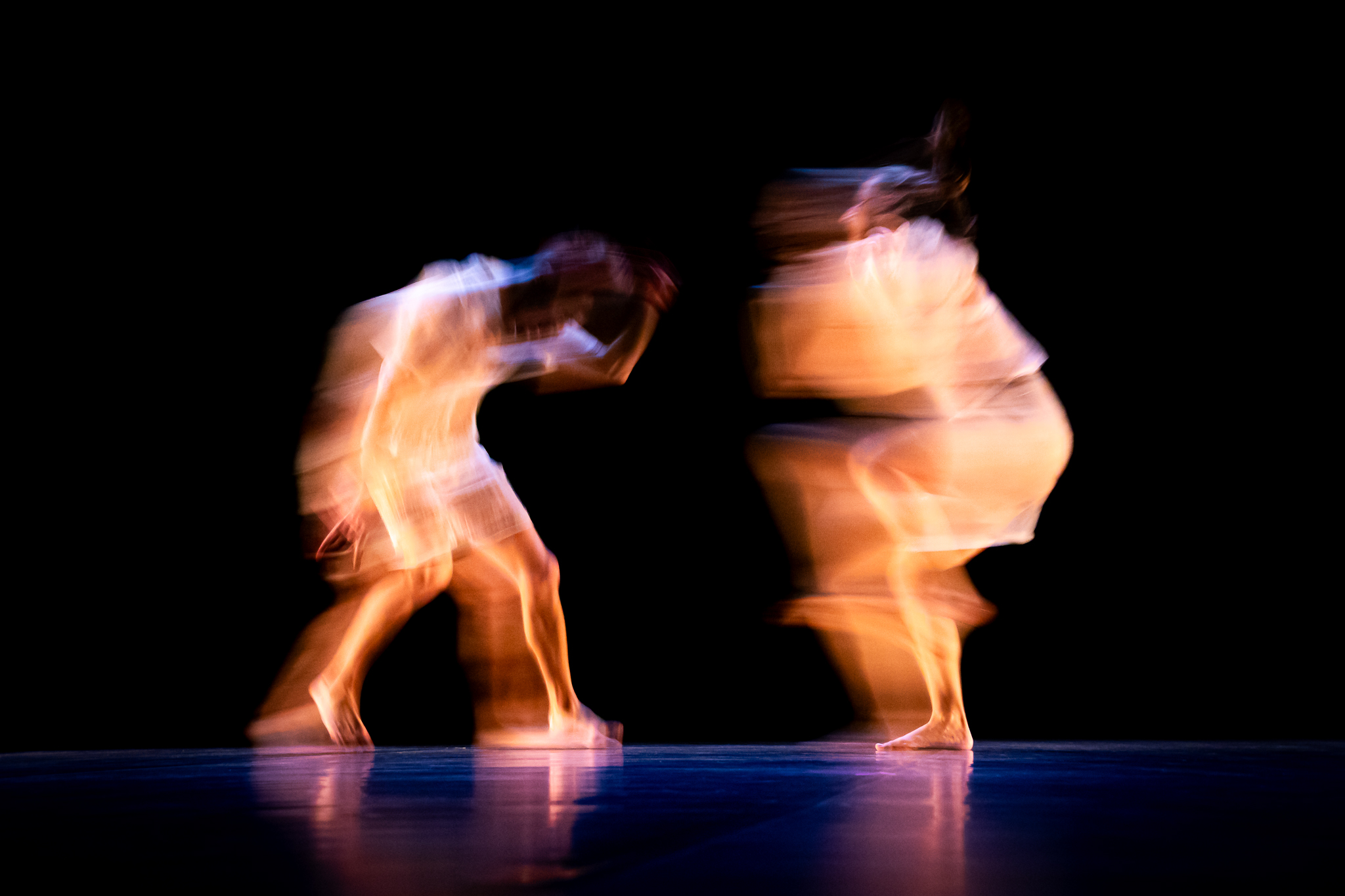 Bailarinos em movimento com arrastamento de imagem em palco escuro