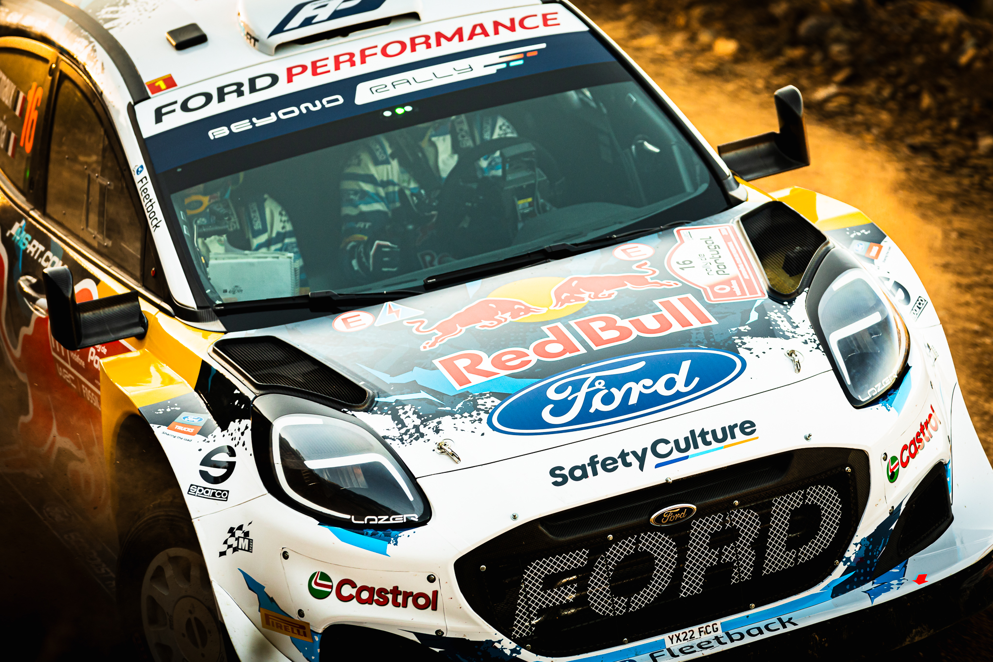 Detalhe frontal de carro de rally com branding Red Bull