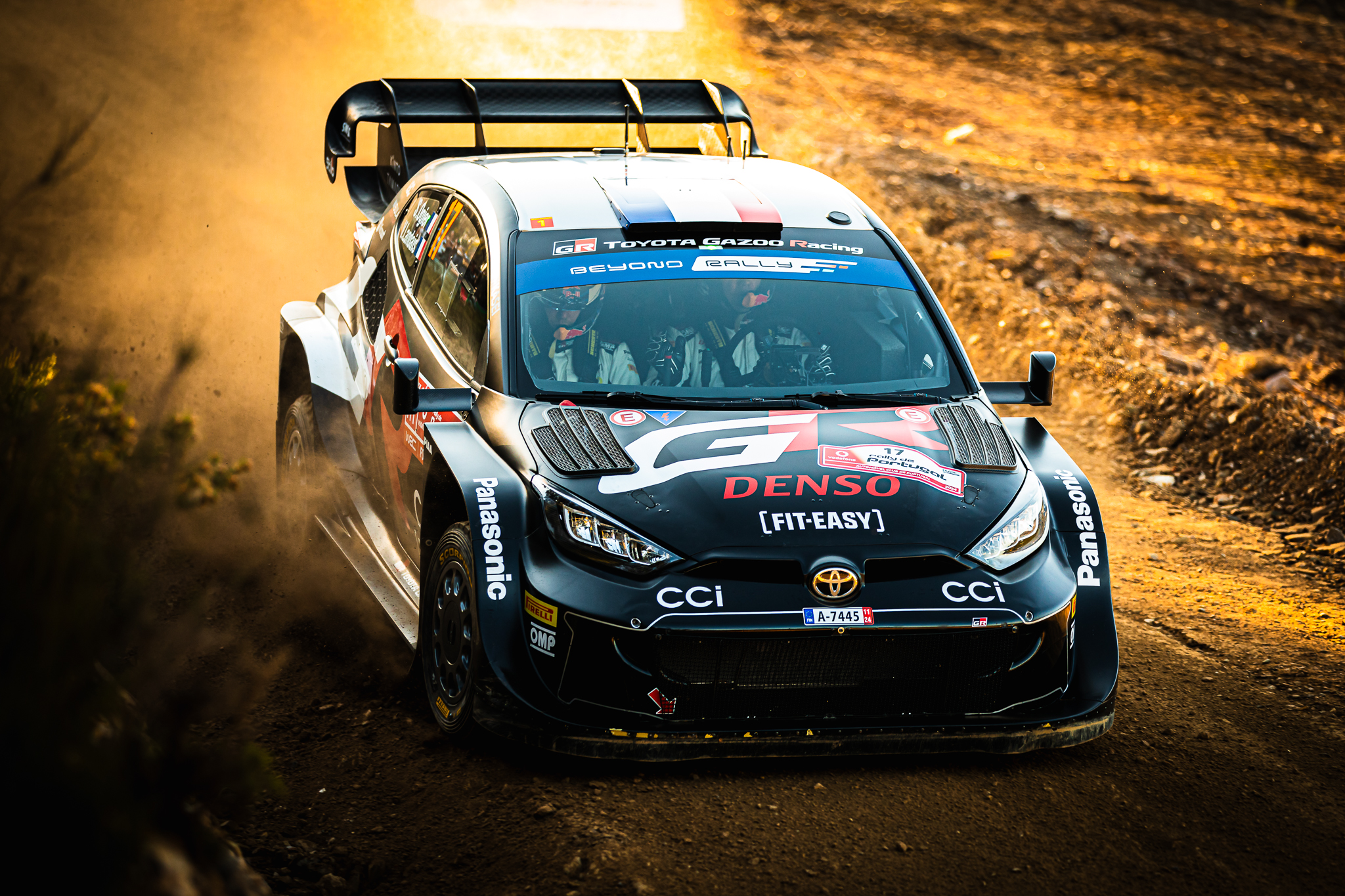 Carro de rally derrapa em curva levantando poeira