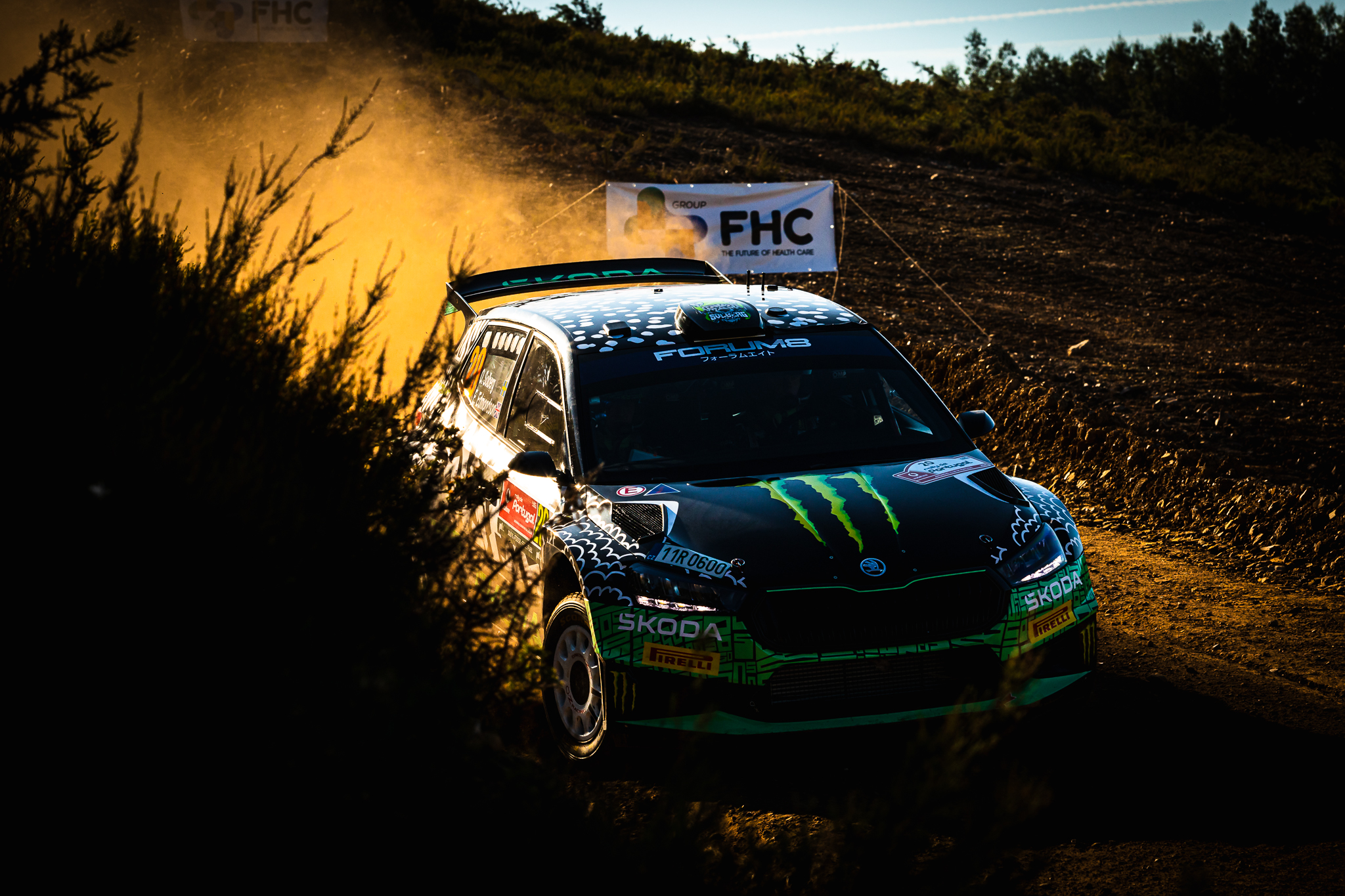 Carro de rally iluminado por luz lateral em ambiente de terra