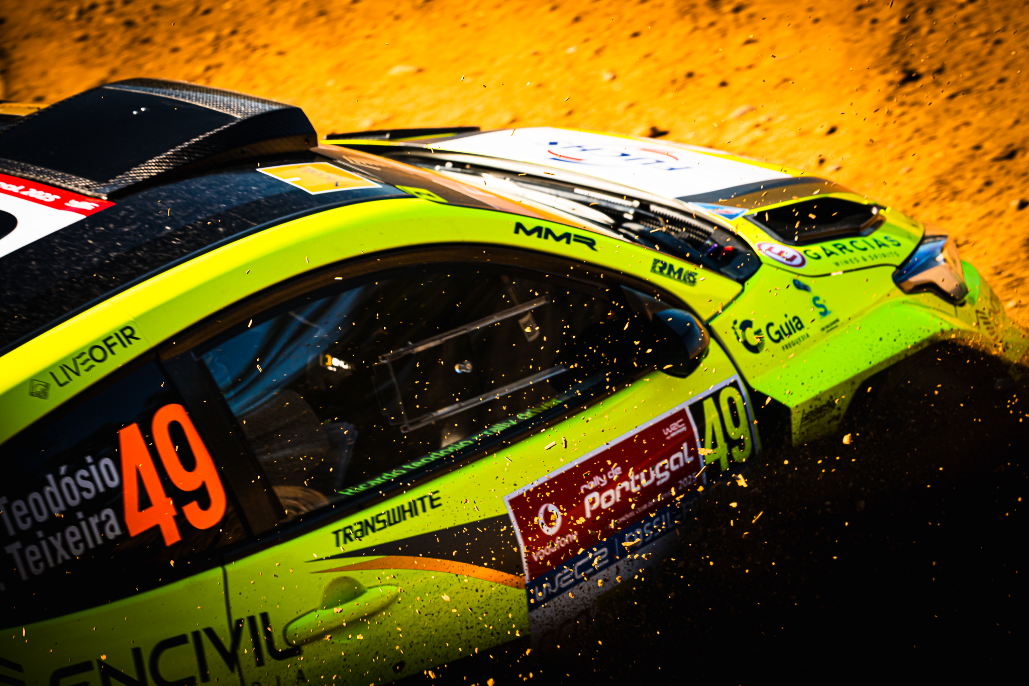 Detalhe de carro de rally em alta velocidade com terra projetada