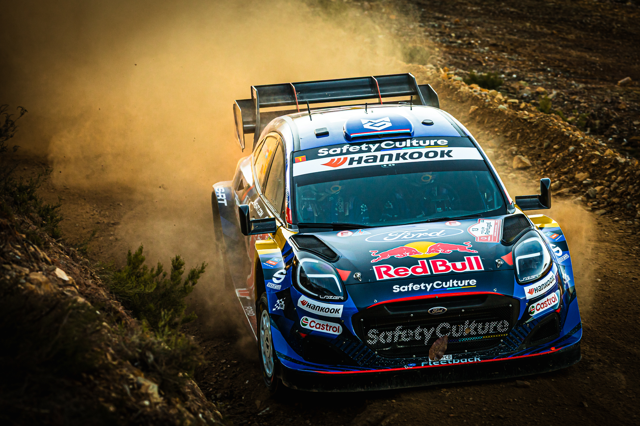 Carro de rally em aproximação frontal com pó e luz quente